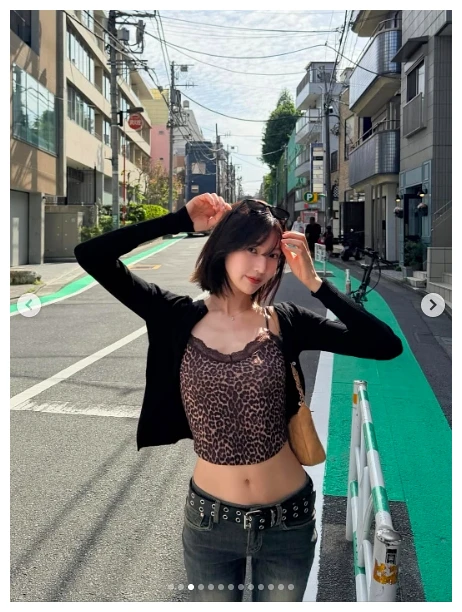 호피무늬 크롭 상의와 로라이즈 데님으로 허리 라인이 드러난 거리 포즈